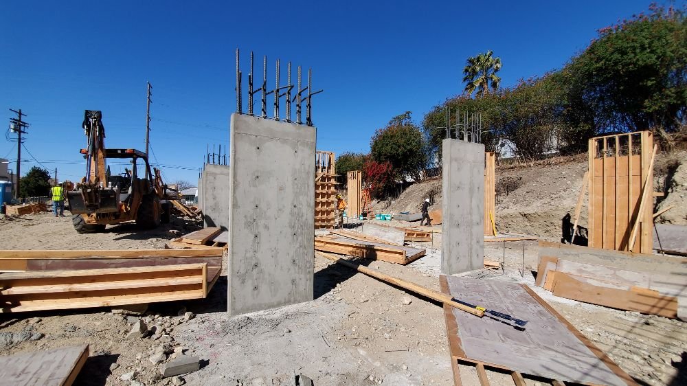 Hillside General Construction Construction site with concrete foundation and framing for an apartment building rebuild project in Alta Dena, California, after wildfire damage.